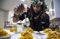 a man with dreadlocks preparing food
